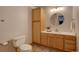 A well lit half bath features a large vanity, built in storage cabinet, tile floors and a round mirror at 32091 Black Widow Dr, Conifer, CO 80433