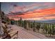Enjoy stunning mountain sunsets from this relaxing deck with wood flooring and metal railings at 32091 Black Widow Dr, Conifer, CO 80433
