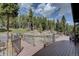 Spacious wooden deck with metal railing overlooking a serene wooded landscape at 32091 Black Widow Dr, Conifer, CO 80433