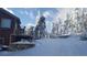 Charming home nestled in a snow-covered landscape with stone accents and a inviting driveway at 32091 Black Widow Dr, Conifer, CO 80433