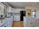 Charming kitchen with white cabinets, marble countertops, and a black refrigerator at 32091 Black Widow Dr, Conifer, CO 80433
