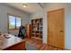 Inviting office space features a beautiful view, stylish wood floors, a built-in bookshelf and a comfortable desk setup at 32091 Black Widow Dr, Conifer, CO 80433