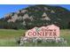 Welcome to Conifer sign nestled in a picturesque meadow with a stunning mountain backdrop at 32091 Black Widow Dr, Conifer, CO 80433