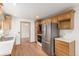 Well-lit kitchen showcasing stainless steel appliances, wood cabinetry, and an open layout for easy access to other areas at 10784 Allendale Dr, Arvada, CO 80004