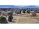 Scenic view of golf course surrounded by mature trees and blue mountains in the distance at 178 E 11Th Ave, Broomfield, CO 80020