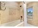 Tiled bathtub and shower with a decorative window at 10158 E Fair Cir, Englewood, CO 80111
