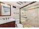 This updated bathroom features a glass shower, neutral tile, updated vanity and fixtures at 10158 E Fair Cir, Englewood, CO 80111