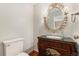 Bathroom with decorative vanity, granite counters, ornate mirror, and sconces at 10158 E Fair Cir, Englewood, CO 80111