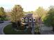 Aerial view showcasing the home's brick facade, lush landscaping, and two-car garage, situated in a well-treed lot at 10158 E Fair Cir, Englewood, CO 80111