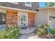 Charming front door with brickwork and stone walkway, framed by vibrant plants at 10158 E Fair Cir, Englewood, CO 80111