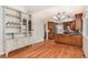 Open kitchen and dining area with hardwood floors, cabinetry, built-in shelving and pendant lighting at 10158 E Fair Cir, Englewood, CO 80111