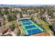 Overhead view of well maintained community tennis courts surrounded by lush greenery and cityscape in the distance at 10158 E Fair Cir, Englewood, CO 80111