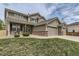 Charming two-story home featuring a covered front porch, three-car garage, and manicured lawn at 11895 Hitching Post Ct, Parker, CO 80134