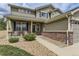 Inviting front porch with white railings, complemented by a beautifully landscaped yard and brick accents at 11895 Hitching Post Ct, Parker, CO 80134