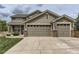 Exterior view showing the three-car garage and driveway at 11895 Hitching Post Ct, Parker, CO 80134