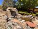 Backyard water feature with boulder-accented waterfall flowing into a koi pond at 11895 Hitching Post Ct, Parker, CO 80134