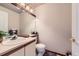 Well-lit half bathroom with white vanity, large mirror, and neutral decor at 7166 Newhall Dr, Highlands Ranch, CO 80130