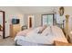 Bedroom with plush bedding, brass bed frame, carpet flooring, and natural light at 7166 Newhall Dr, Highlands Ranch, CO 80130