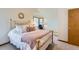 Bright bedroom with a brass bed frame, plush bedding, and a view of bay windows at 7166 Newhall Dr, Highlands Ranch, CO 80130