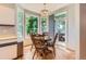 Sunlit breakfast nook features wood floors, a modern chandelier, and backyard views at 7166 Newhall Dr, Highlands Ranch, CO 80130