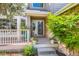 Inviting front porch with a warm welcome sign, stone facade, and a charming seating area with potted plants at 7166 Newhall Dr, Highlands Ranch, CO 80130