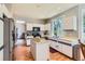 Efficient kitchen with stainless steel appliances, an island, white cabinetry, and a view into the dining area at 7166 Newhall Dr, Highlands Ranch, CO 80130