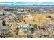 An aerial view shows a modern home with a large yard near a playground, businesses, and distant mountain views at 3910 Reed St, Wheat Ridge, CO 80033