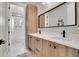 Modern bathroom with double sinks, a large mirror, and access to the shower and bath area at 3910 Reed St, Wheat Ridge, CO 80033