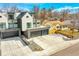 An eye-level exterior view of a modern home with multi-level decks, a well-manicured yard, and a spacious driveway at 3910 Reed St, Wheat Ridge, CO 80033