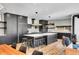 Stylish kitchen with modern black cabinets, a large island with seating, and hardwood floors at 3910 Reed St, Wheat Ridge, CO 80033