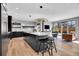 Modern kitchen featuring a large center island with seating, sleek black cabinetry, and stainless steel appliances at 3910 Reed St, Wheat Ridge, CO 80033