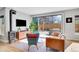 Bright living room with hardwood floors, modern fireplace, leather sofa, and access to outdoor patio at 3910 Reed St, Wheat Ridge, CO 80033