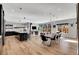 Open-concept living room with hardwood floors, modern lighting, dining area, and large sliding doors to the backyard at 3910 Reed St, Wheat Ridge, CO 80033