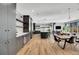 Bright, open-concept kitchen and dining area with sleek black cabinets and wood flooring at 3910 Reed St, Wheat Ridge, CO 80033