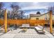 A beautiful patio features an outdoor seating area with a wooden fence, a fire pit, and comfortable couches at 3910 Reed St, Wheat Ridge, CO 80033