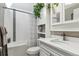Bright bathroom featuring white cabinets, a bathtub, a shower, and modern fixtures at 7770 S Estes St, Littleton, CO 80128