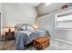 Bedroom with sloped ceilings, a wrought iron bed, wooden trunk, and a cozy atmosphere at 7770 S Estes St, Littleton, CO 80128