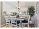 Cozy dining area featuring a wooden table with blue cushions and a decorative light fixture and mirror at 7770 S Estes St, Littleton, CO 80128