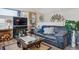 Cozy living room with a brick fireplace, a dark leather sofa, and a glass coffee table at 7770 S Estes St, Littleton, CO 80128
