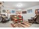 Comfortable living room with a leather sofa, accent chairs, and Southwestern-inspired rug at 7770 S Estes St, Littleton, CO 80128