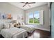 Bright bedroom featuring two twin beds, hardwood floors, a ceiling fan, and a window with plantation shutters at 4875 S Monaco St # 303, Denver, CO 80237