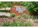 Community sign reading 'Villa Rosso Residences at DTC West' with well-maintained landscaping and colorful flowers at 4875 S Monaco St # 303, Denver, CO 80237