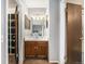 Hall bathroom featuring a vanity sink, mirror, decorative lighting and storage closet at 8746 Carr Loop, Arvada, CO 80005