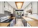 Bright kitchen with white cabinets, butcher block countertops, and stainless steel appliances at 8746 Carr Loop, Arvada, CO 80005