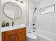 Updated bathroom with subway tile, a wood vanity, and a shower-tub combo at 1987 S Downing St, Denver, CO 80210