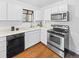 Well-lit kitchen with white cabinets, stainless steel appliances, and hardwood floors at 1987 S Downing St, Denver, CO 80210