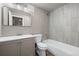 Updated bathroom with gray vanity, wood-look tile and shower-tub combination at 12919 W Burgundy Dr, Littleton, CO 80127