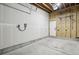 Unfinished garage with concrete floor, door to inside, electrical boxes, and storage rack at 1286 Raleigh St, Denver, CO 80204