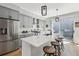 Modern kitchen features stainless steel appliances, a white quartz island with seating, and stylish pendant lighting at 1286 Raleigh St, Denver, CO 80204