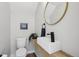 Modern powder room featuring a floating vanity, vessel sink, round mirror, and stylish decor at 1286 Raleigh St, Denver, CO 80204